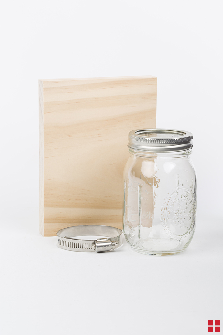 Mason jar vase with a mirror glass finish mounted to a wooden board to make a wall sconce.